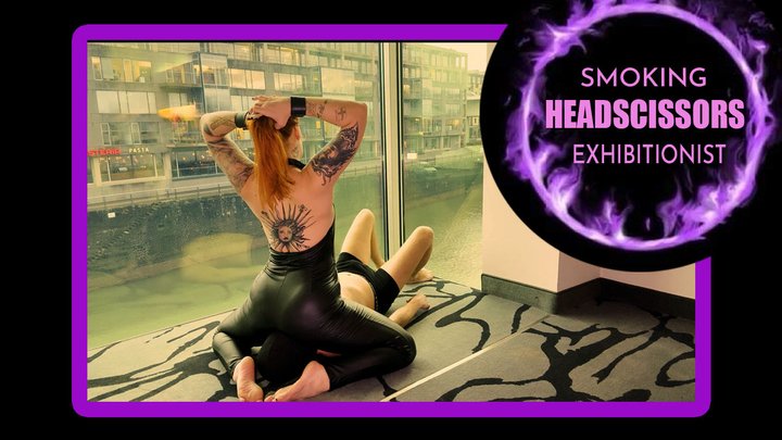 The Redhead's Throne: Mel Fire smokes while delivering a Punishing Leg Scissors 