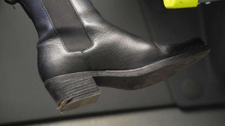 Bratty woman with dirty riding boot close-up. Boot fetish admiration and inspect