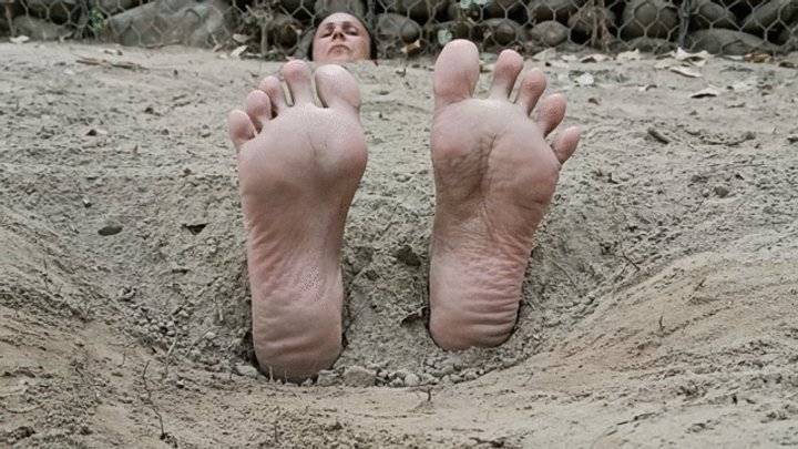 Buried on the beach with only my feet and head outside, my soles are tickled a l