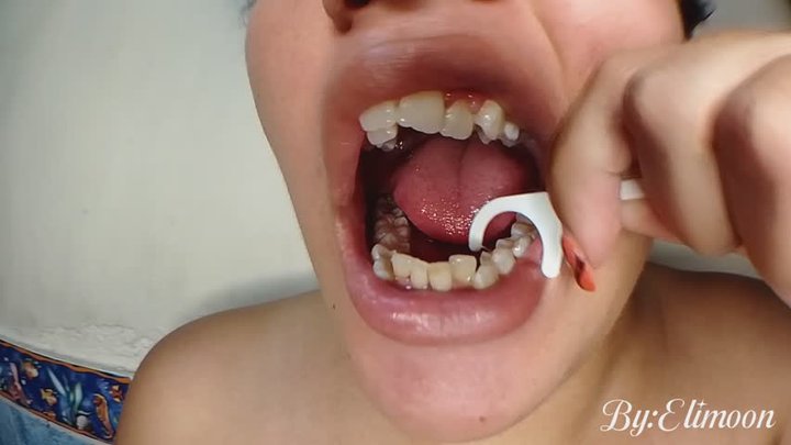 Using dental floss with clean teeth (close-up) after brushing teeth