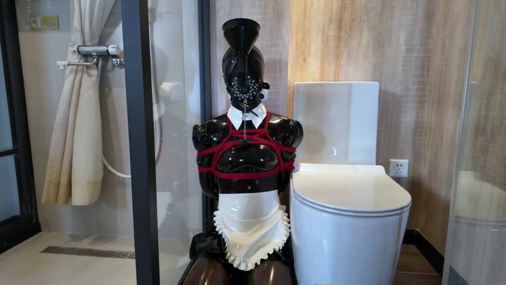 A maid bound with red rope, in the bathroom.