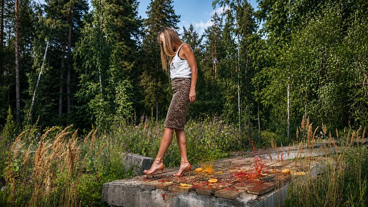 GIANT IN HIGH HEELS. CRUSHING ORANGES, TOMATOES & PLUMS UNDER MY HIGH HEELS SAND