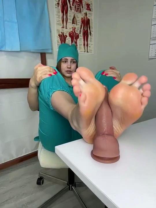 A nurse masturbates a penis with her feet.